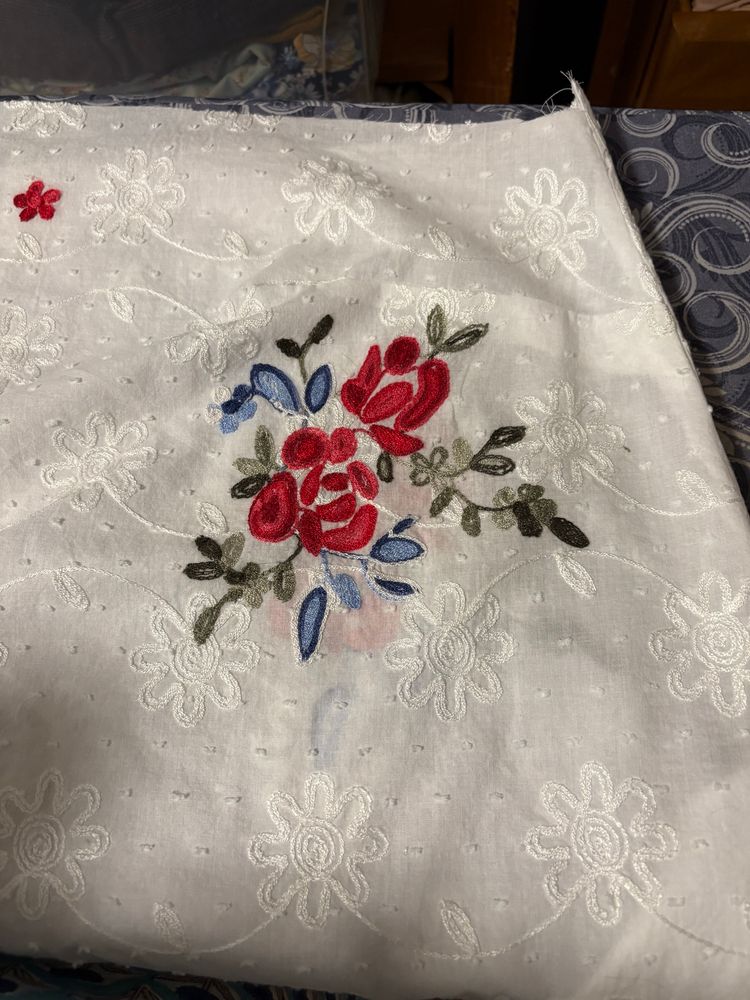 A close up of white fabric with embroidered flowers