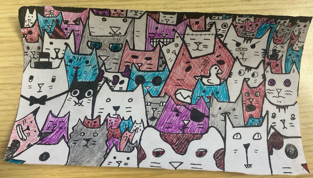 a doodle of cats on a small piece of scrap paper