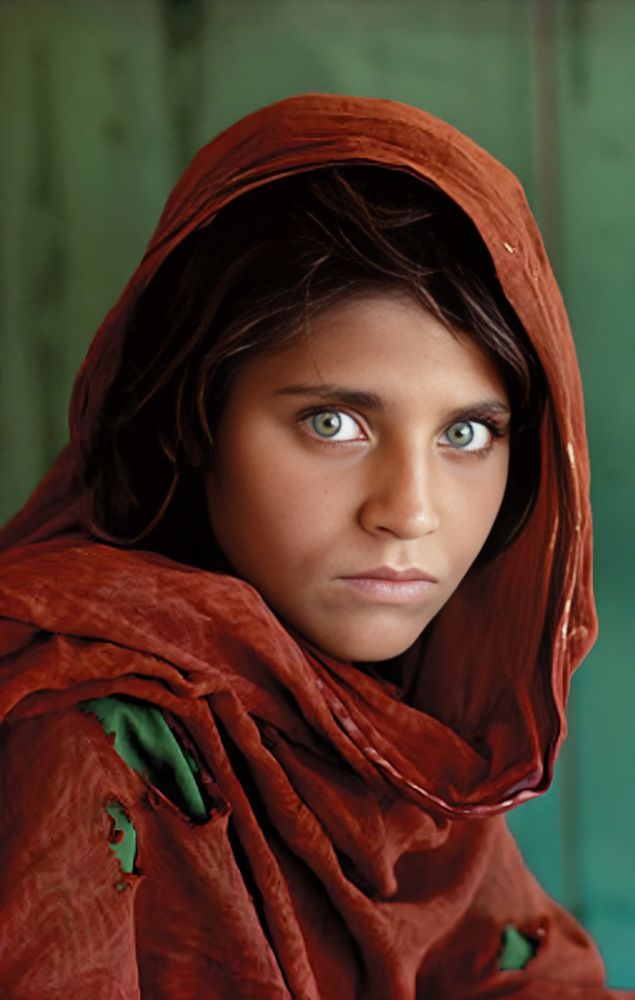 The iconic Afghan Girl portrait, taken by Steve McCurry in 1984, features Sharbat Gula, a refugee with striking green eyes. Captured in a Pakistan refugee camp, the image became a symbol of resilience and the plight of displaced people, gracing National Geographic’s cover.