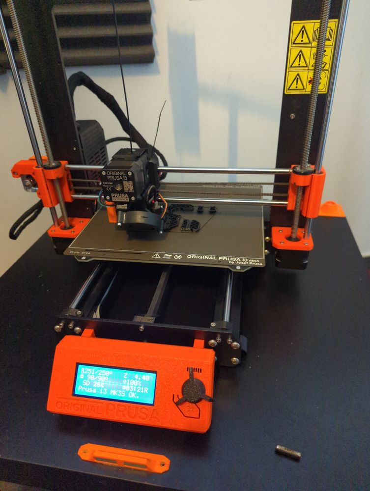 Ein Prusa i3S+ druckt die ersten Teile für das Upgrade auf 3.9. Davor liegt die defekte Heizsonde.