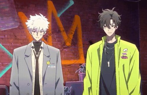 two anime characters are standing next to each other in front of a brick wall with graffiti on it