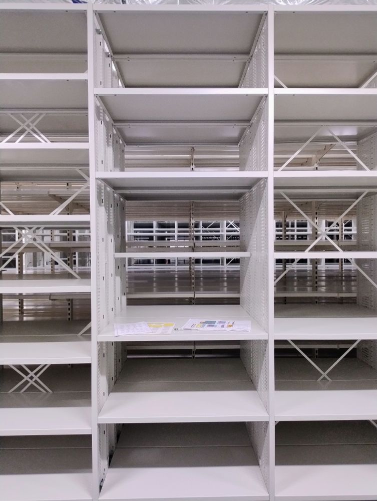 An array of shelves with barcode labels ready to be affixed.