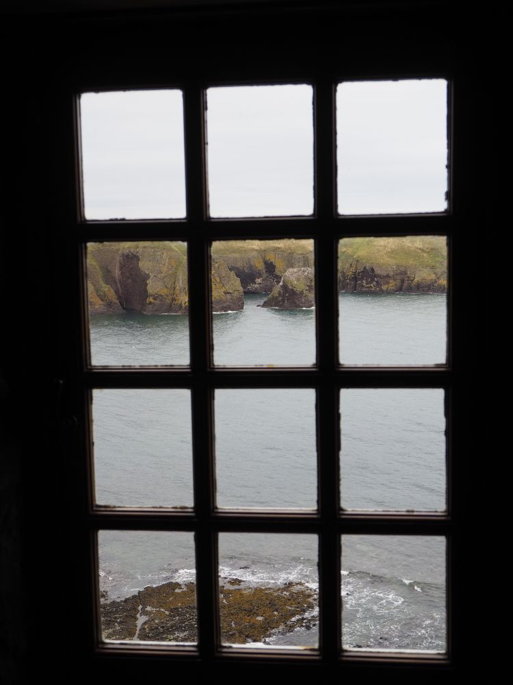View through a glazed window onto a rocky bay.