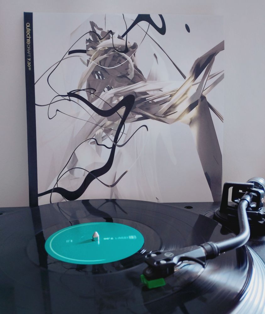 Black vinyl LP playing with album sleeve behind 