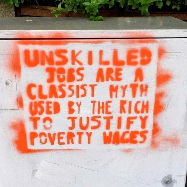 Stenciled graffiti in orange/red that reads:

Unskilled jobs are a classist myth used by the rich to justify poverty wages