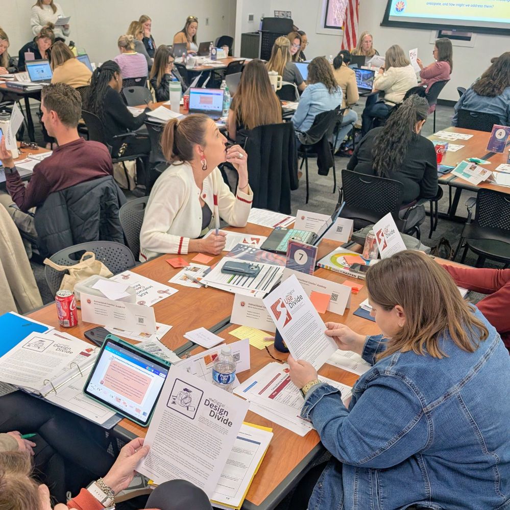 A table of coaches reading portions from the 2024 National EdTech Plan.