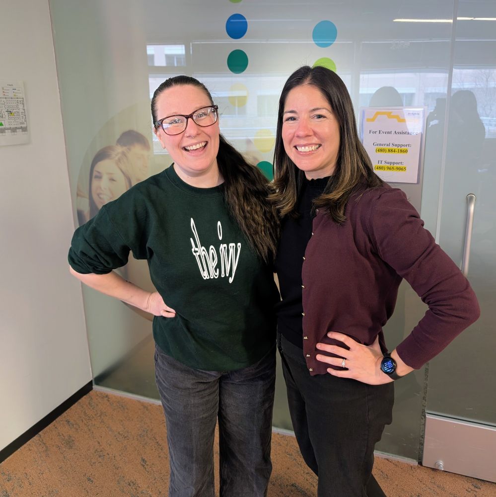 Two women standing in front of a door smiling