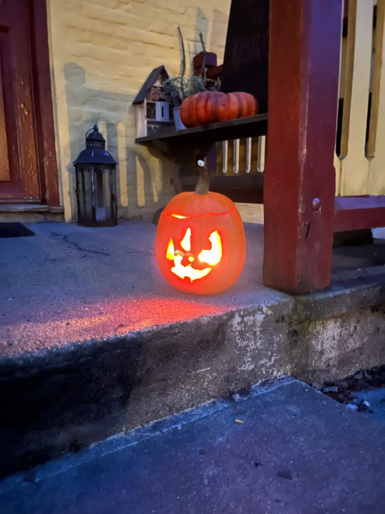 Nærbilde av graskarlykta på trammen. Det gliser skakt og fint.