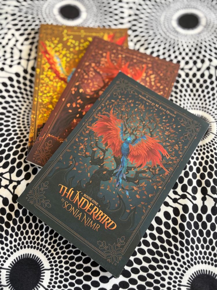 Three books with beautiful flame winged birds on the cover. Thunderbird series by Sonia Nimr. 
