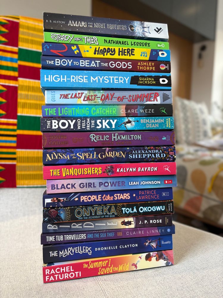 Huge stack of Black authored kids books sitting on my chair 