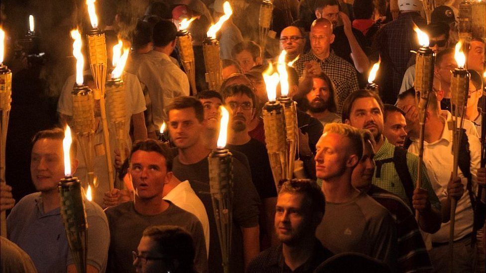White men marching with tiki torches in Charlottesville.