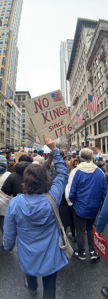 Protestor with painted sign That says No Kings since 1776, with American Flag. From April 5, 2025 