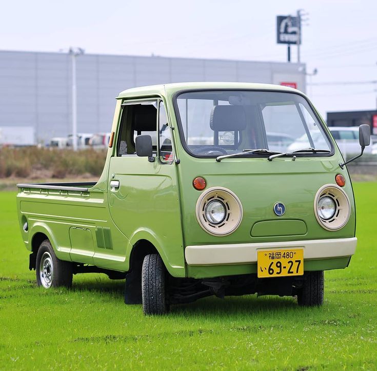 A green Mazda Porter kei truck. It's got round headlights and looks slightly like a cartoon bear.