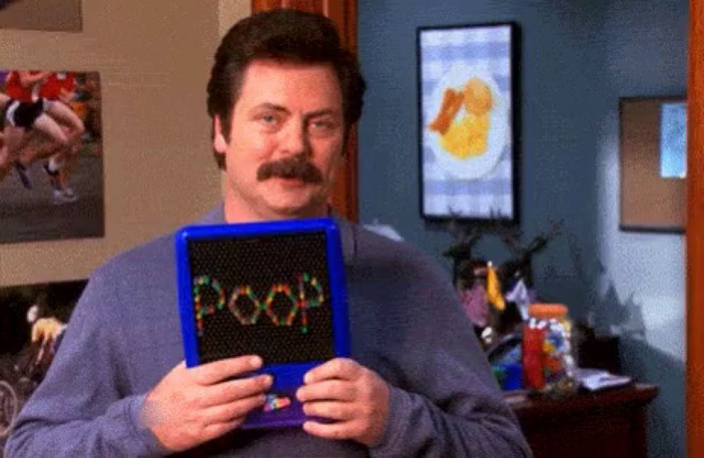 a man with a mustache is holding a blue board with the word poop on it