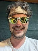 Me wearing gold sunglasses and open top hat with transparent brim.