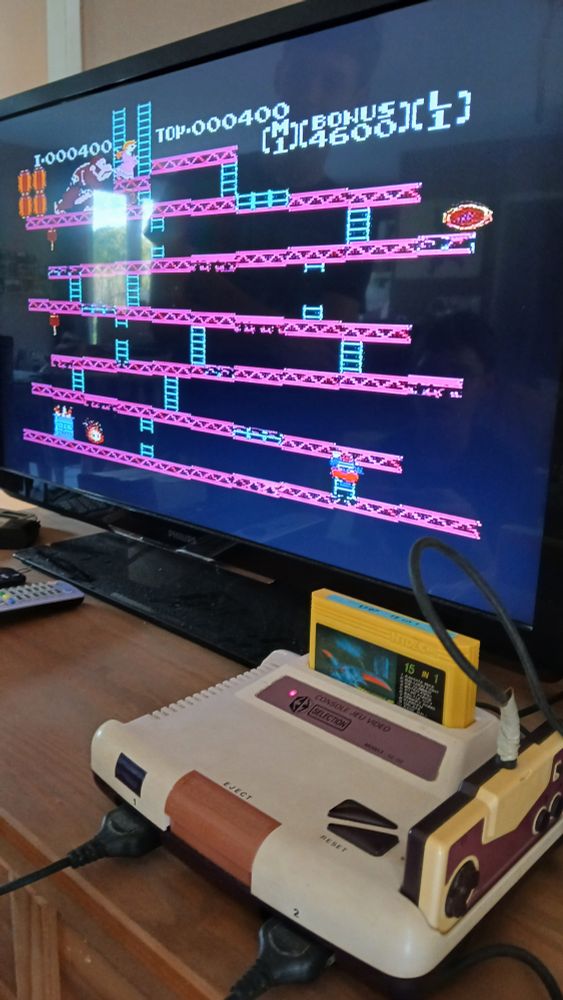 Photo montrant la console au premier plan et la télé en fond avec le jeu Donkey Kong (contrefaçon/copie de la version NES)