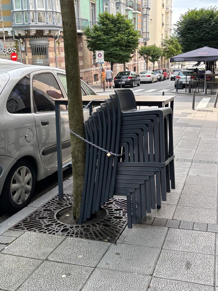 Mobiliario de terrazas atado con cadenas a árboles en la calle Lope de Vega