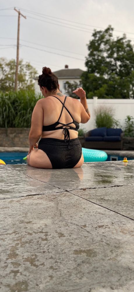 Margo in a black bikini at the pool side 