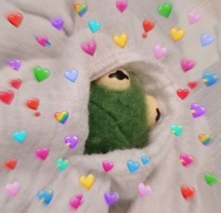 Kermit the frog wrapped up in a blanket with lots of blurry heart emojis