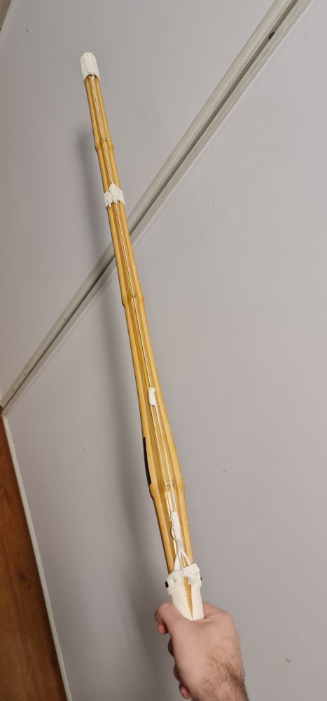 the image shows a hand holding a kendo Shinai 