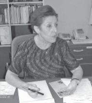 Belkis Valdman sat at desk in B&W photo