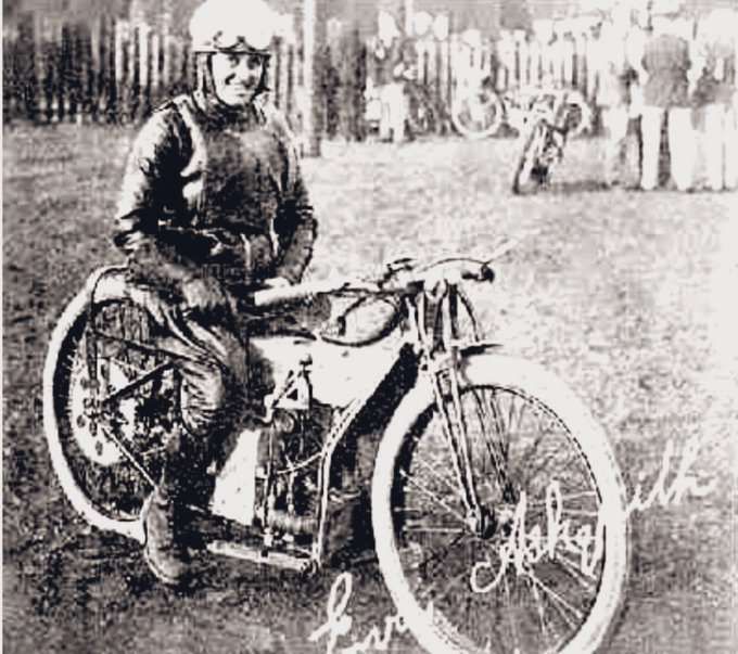 Eva Askquith sat on her speedway motorcycle in full racing leathers, her signature is bottom right of B&W photo
