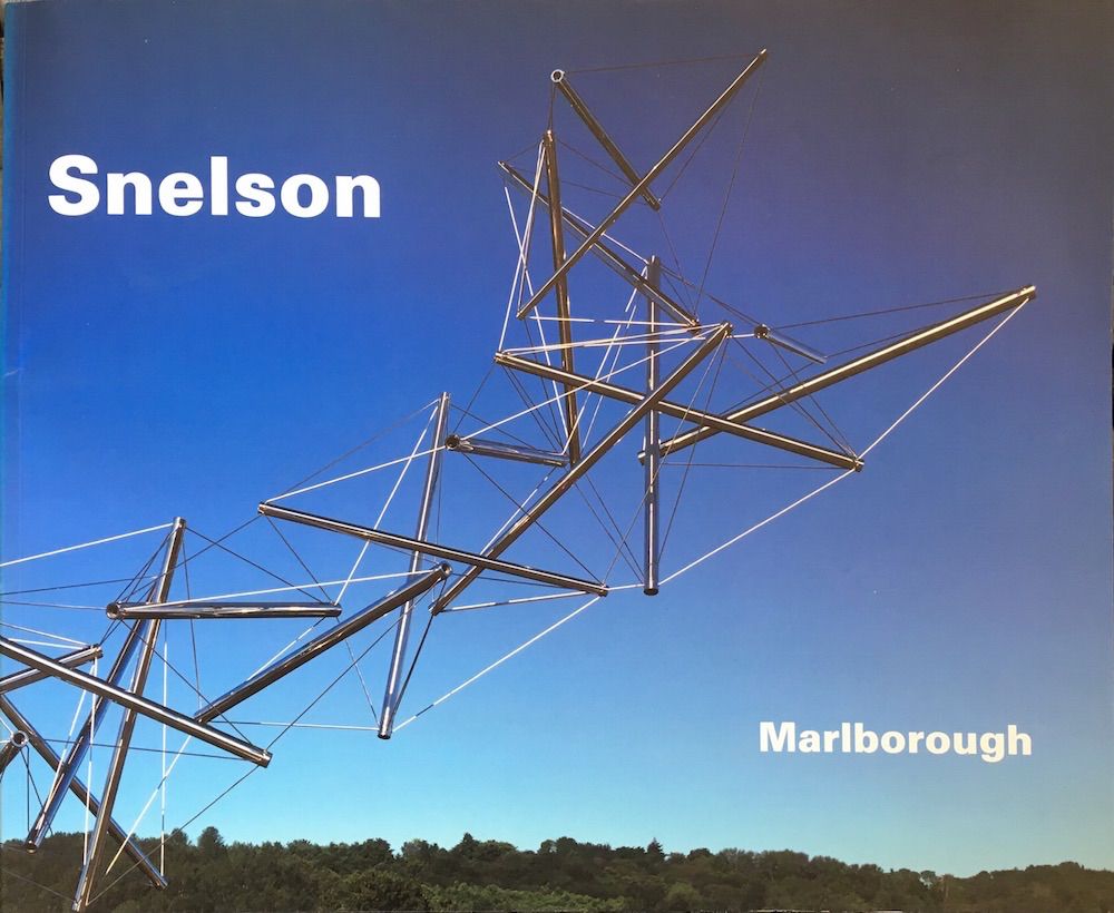 An horizontal format exhibition catalog of the work of American sculptor Kenneth Snelson, published by Marlborough Gallery, New York in 2003. The cover shows one of the artist's large modern stainless steel works set against a blue sky. Only the words 'Snelson' and Marlborough' appear on the cover in white letters.