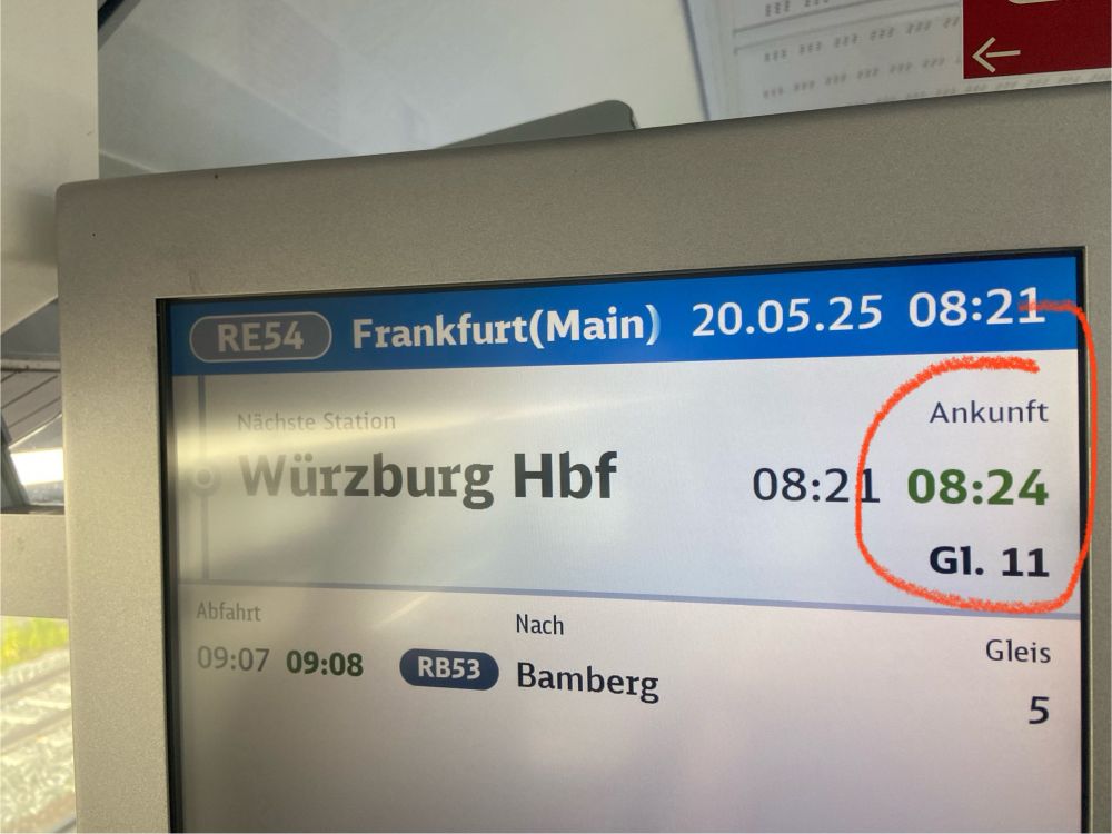 Ein Foto des Fahrgastinformationssystems des Zugs der DB. Die Ankunftszeit ist grün gefärbt 