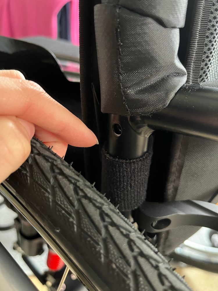 Seitenstrebe über einem Rad in dem ein loch zu sehen ist darunter an der Strebe eine Rückenlehnen Band