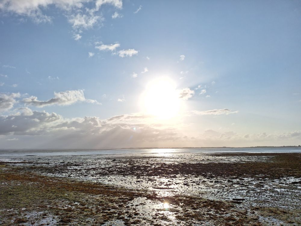 Image shows Langstone harbour at mid tide under a mainly clear sky 