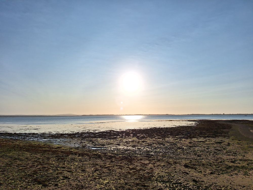 Image shows Langstone harbour at near high tide under a clear, sunny sky 