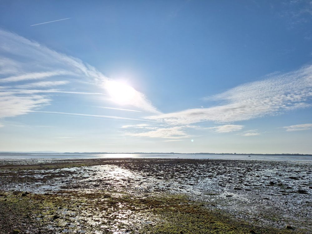 Image shows Langstone harbour at near low tide under mainly clear sky 
