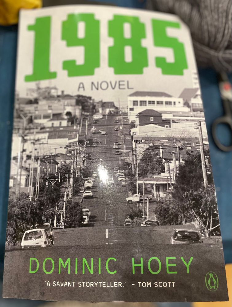 The cover of Dominic Hoey’s novel 1985  A black and white photo of Crummer Road, Grey Lynn, Auckland. The title is rendered in a spacies game typeface in a bright grassy green. 