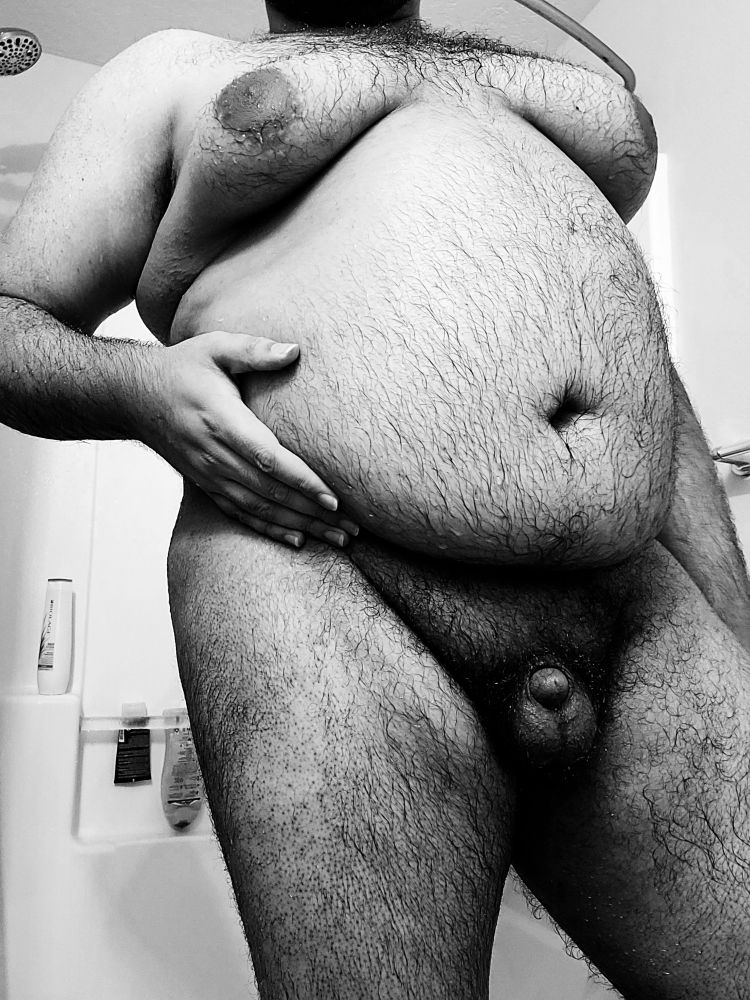 Chubby man, but from a different angle so you can see more of his wet belly and soft cock.