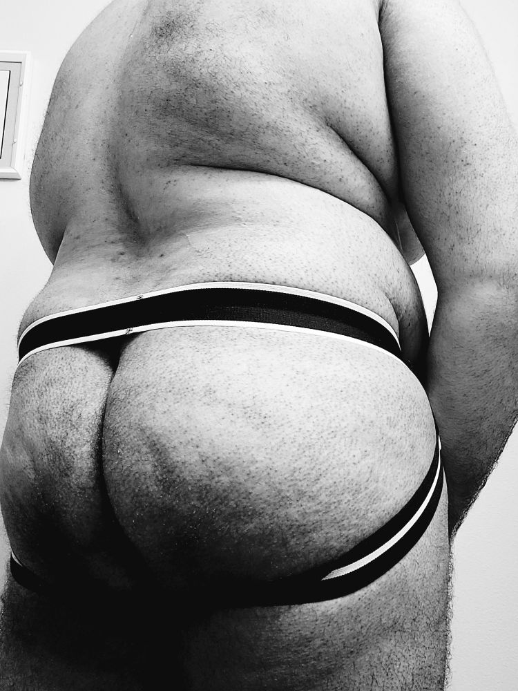 Chubby man turned around and showing off his buns in a jock.