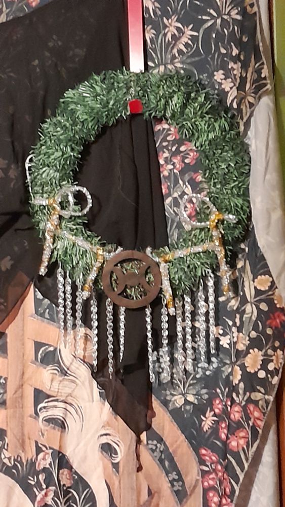 A Yule wreath I handmade out of faux evergreen ties, a handful of artificial icicles, a wooden triple moon altar tile, and two silver and gold tinsel Yule bocks constructed from pipe cleaners. 

The wreath is suspended from a red wreath hanger in front of two curtains. One curtain is black and the other is a tapestry of the Unicorn in Captivity painting. 

...---...

PLEASE HELP DISABLED TRANS PERSON TRYING TO ESCAPE FINANCIAL ABUSERS 

CHRISTIAN ZIONISM IS INHERENTLY ANTISEMITIC. GENOCIDE IS NOT OKAY. GET EDUCATED ABOUT ISRAEL'S HISTORY. FREE PALESTINE. 