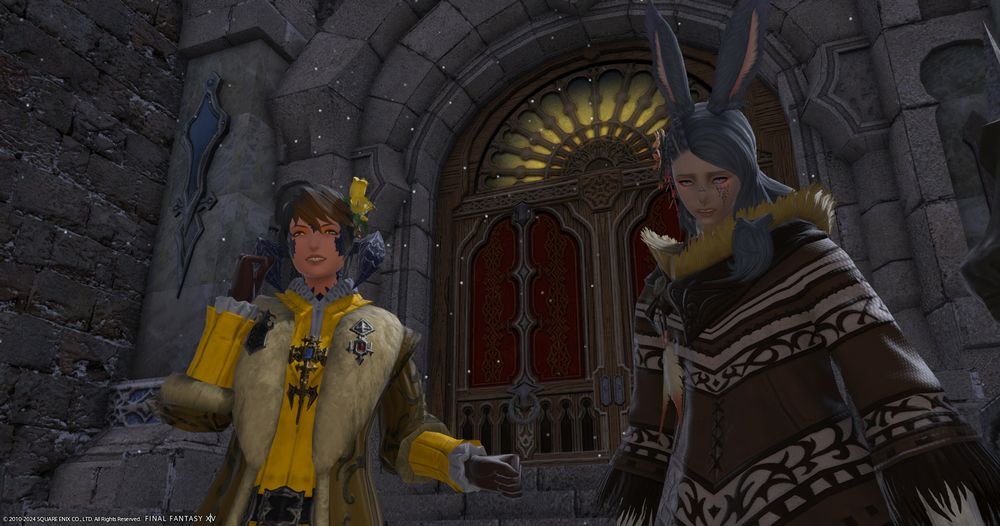 A screenshot of Qaliyun, an au ra woman, cheering next to Seeker, a dejected-looking viera man, in front of Aymeric's house.