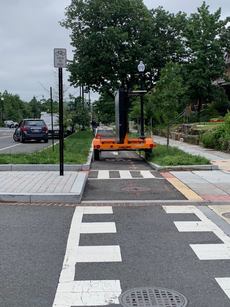 A trailer with a construction notification sign has been positioned to completely block the C Street protected bike lane, despite an adjacent open parking space