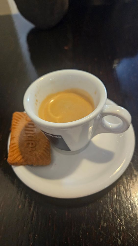 Photo d'un Espresso et un biscuit sec sur une soucoupe blanche.