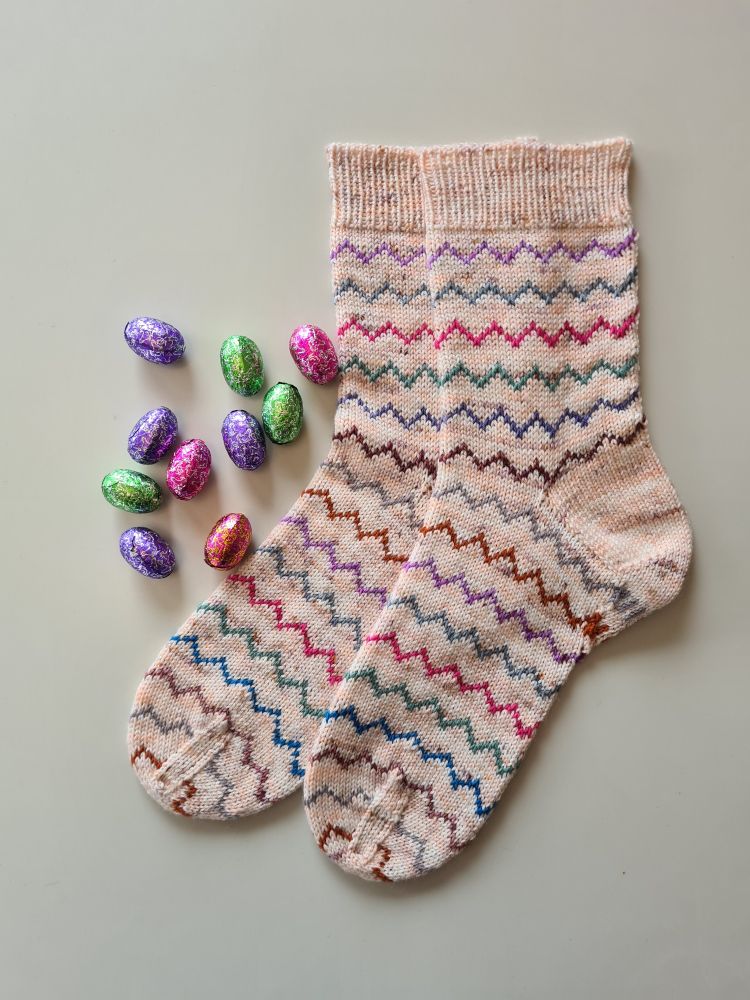 Colourful Easter socks and small chocolate eggs.