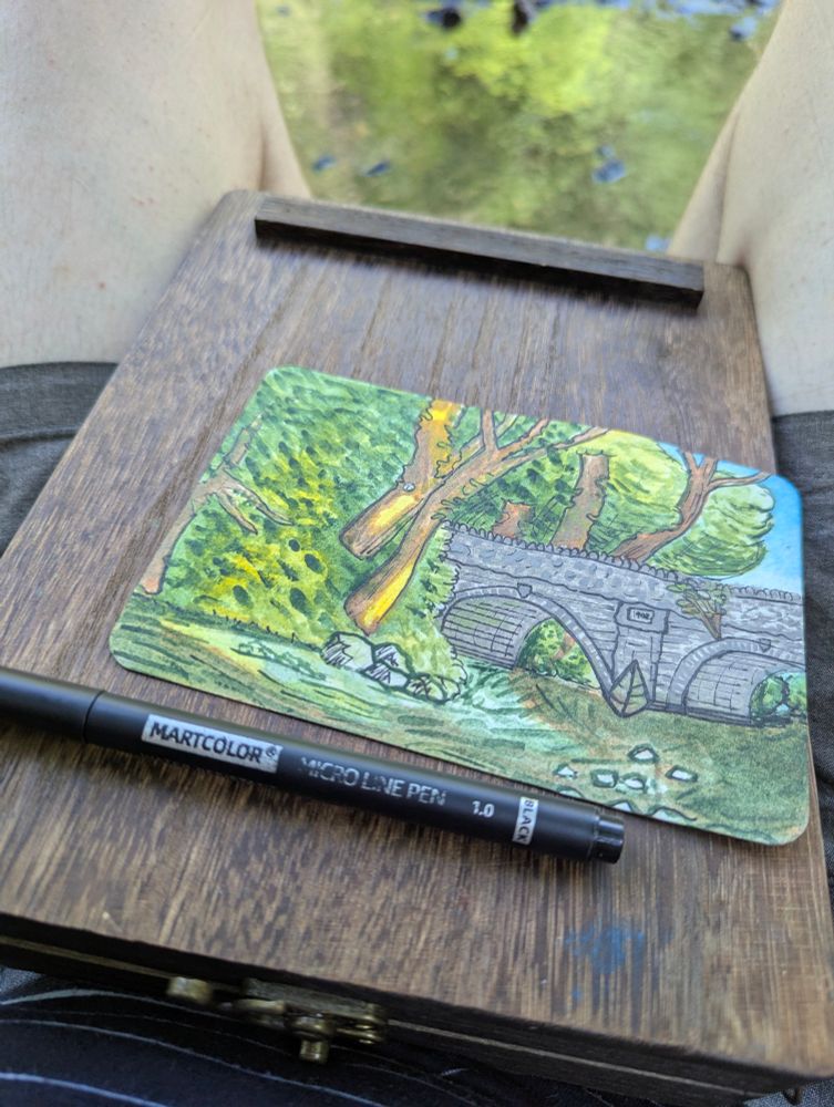 The finished painting, which shows a riverside and a stone bridge that lost some details when I did the ink outlines. 