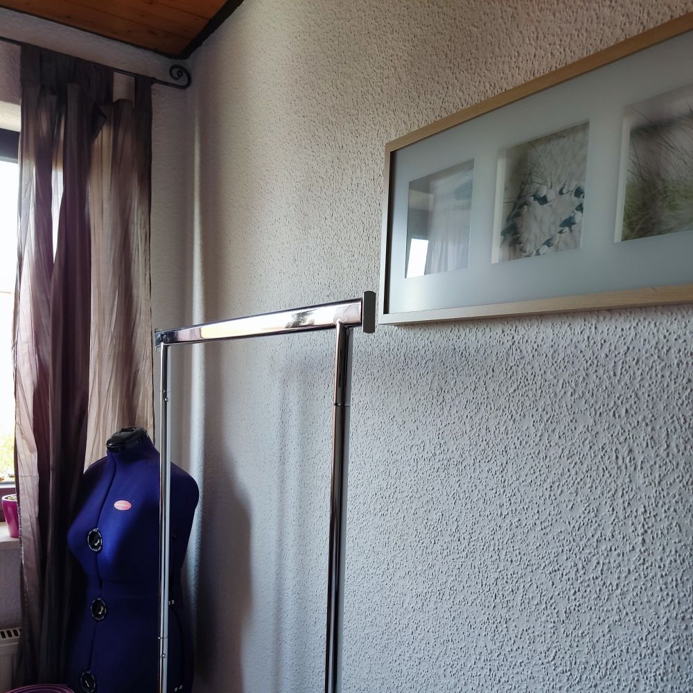 Leerer Wäscheständer auf Rollen. Normalerweise voller Bügelwäsche, wie z.B. Blusen und Hemden, hängend.