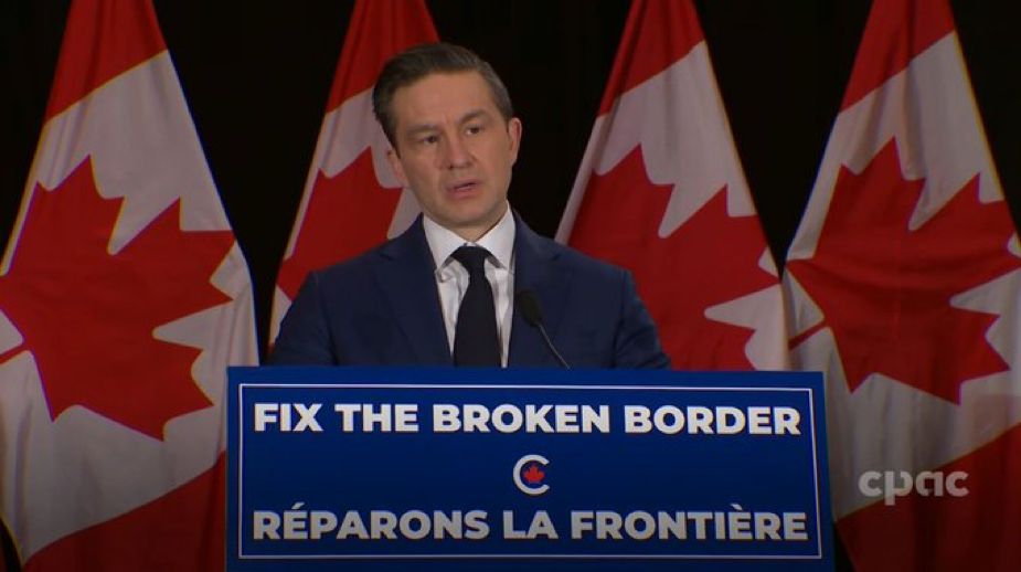 Pierre Poilievre speaking at a lectern with the slogan “Fix the Broken Border”