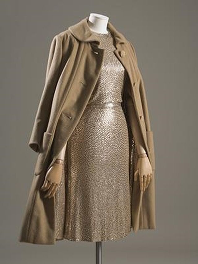 A long sleeved camel overcoat open to reveal a sequinned dress of the same colour