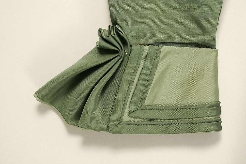 Cuff detail in two shades of green, pleated and trimmed