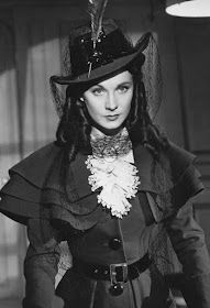 A black and white photograph of Vivien Leigh wearing the green wool coat, worn with a silk top hat and a lace cravat, designed by Rene Hubert