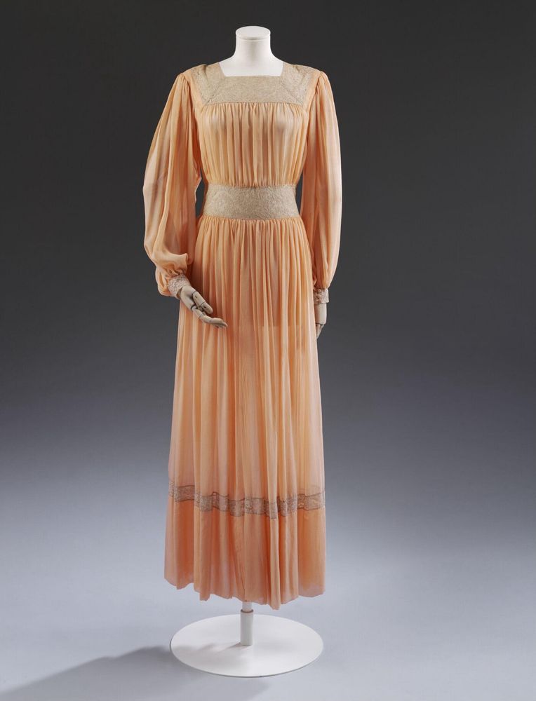 Full length view of the 1940s peach silk tea gown showing the lace inserts and pleats and drapes of the gown