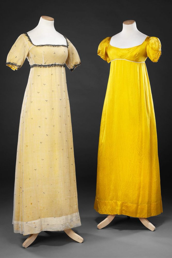 Two mannequins, one wearing a white high waisted embellished gown on the left and the other in a bright yellow underdress on the right 