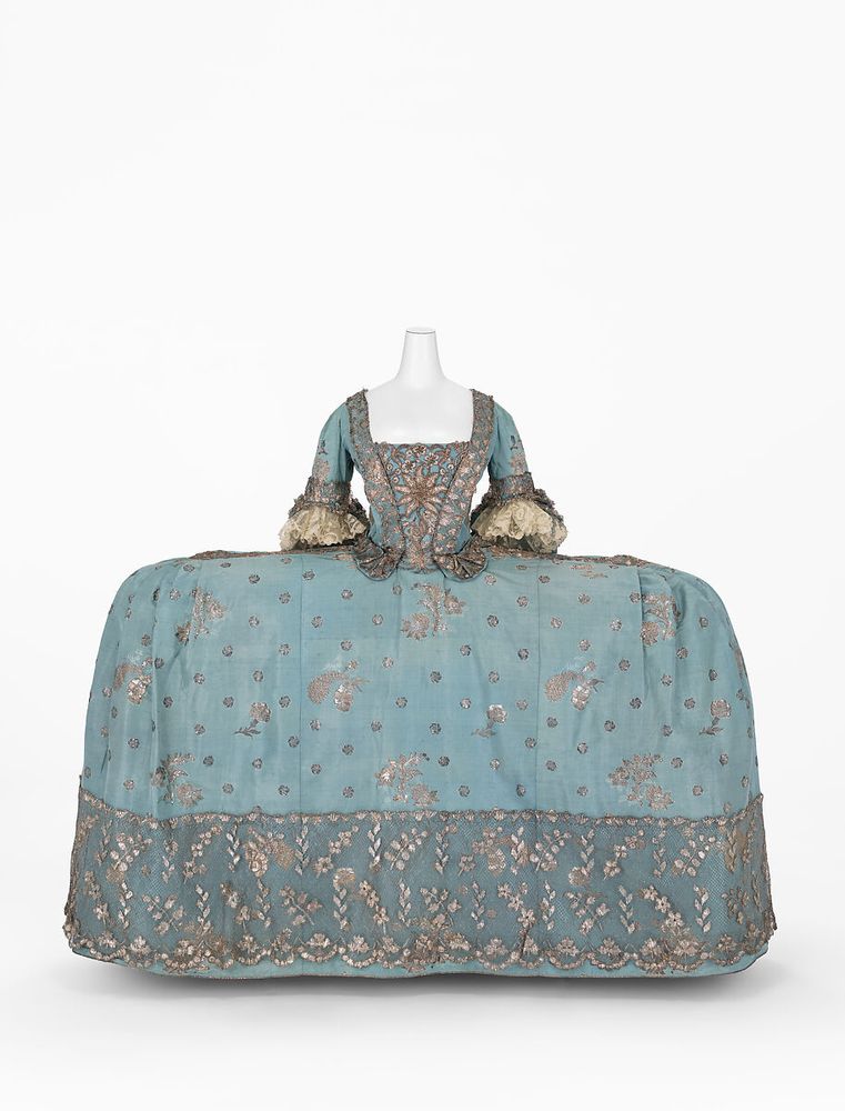 A powder blue court dress with wide, flat expansive skirt, bodice and stomacher all trimmed with silver embroidery and lace