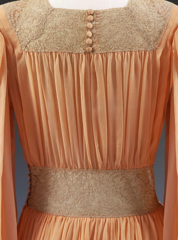 Back detail of the 1940s peach silk tea gown showing the pleats and gathers as well as the lace inserts at neck and waist. It has small covered buttons centre back of the neck